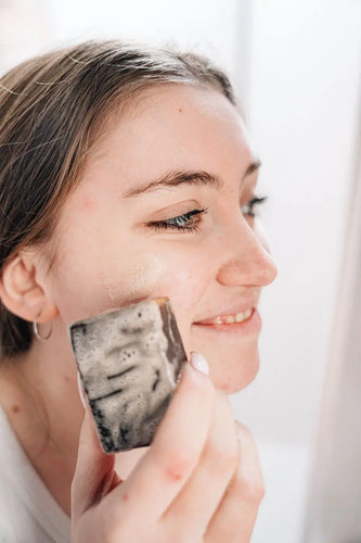 Woman using coffee soap on skin